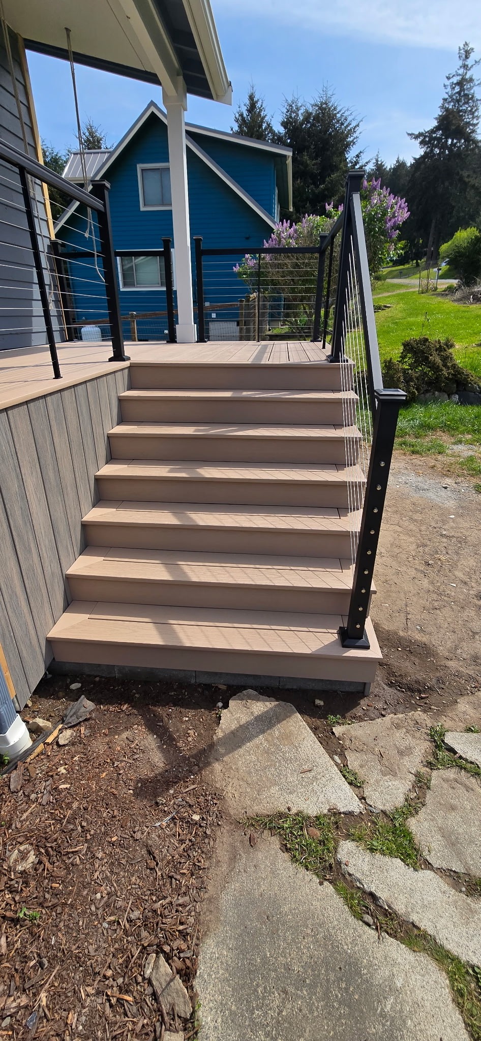 Composite staircase with cable railing leading to front porch