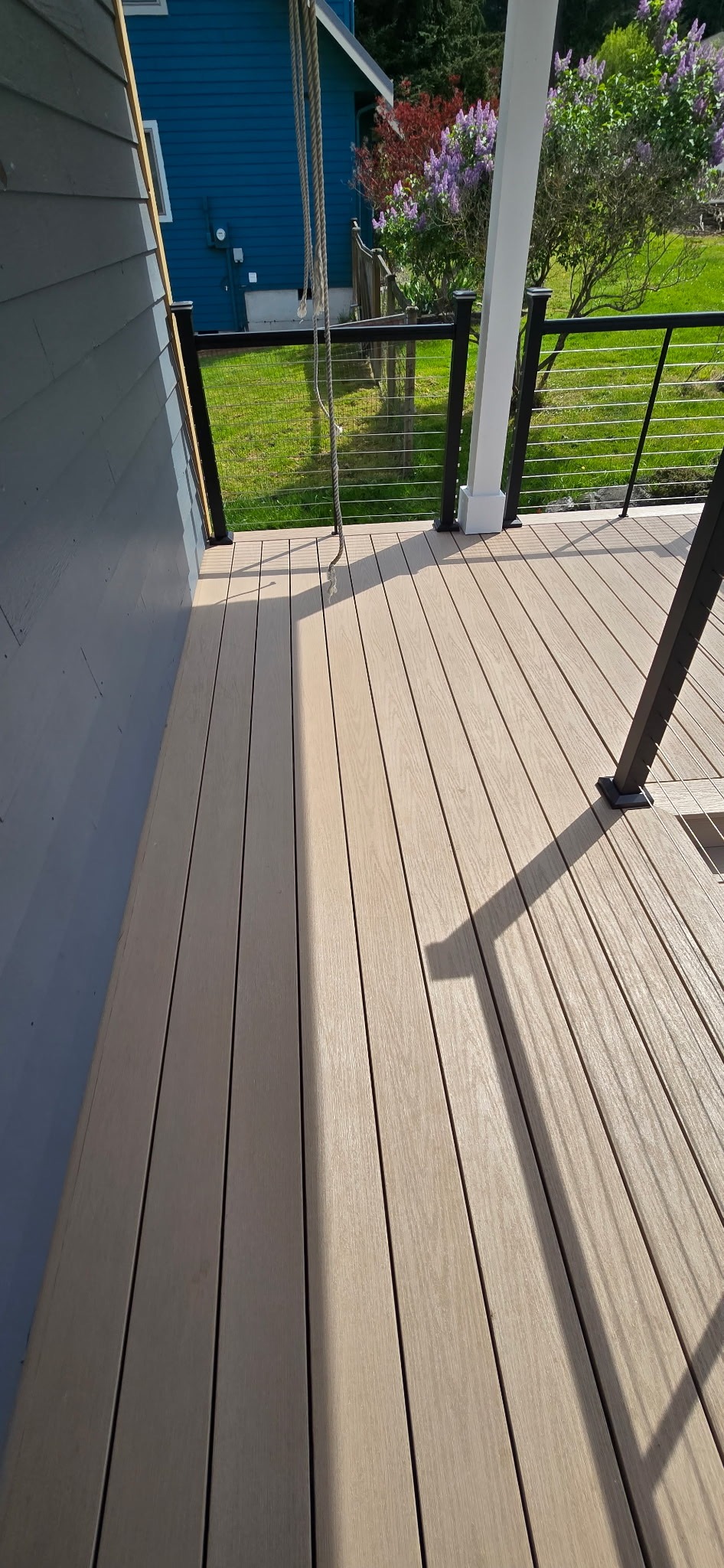 Composite deck flooring with cable railing and covered porch