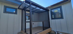 Covered back deck with black framing and screened panels in Coupeville, WA